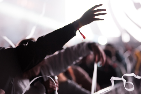 Rear view of silhouette of crowd with arms outstretched at concert. Summer music festival conceptの写真素材