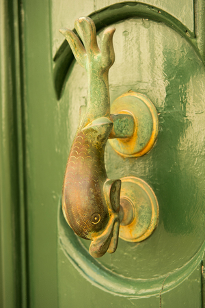 Close-up view of the fish shaped knocker on a green wooden door. Mdina, Maltaの写真素材