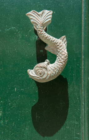 Close-up view of the fish shaped knocker on a green wooden door. Valetta, Maltaの写真素材