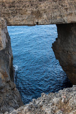 Wied il Mielah canyon and natural arch over the sea in Gozo, Maltaの写真素材