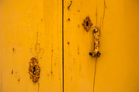 Rusty vintage keyhole on a yellow wooden doorのeditorial素材