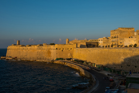 VALLETTA, MALTA - AUGUST 21, 2017: Valletta the beautiful capital city of Malta is visited daily by crowds of tourists. Sunset lights illuminate the seaside buildings of Vallettaのeditorial素材