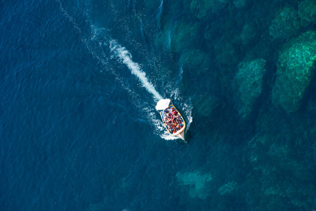 BLUE GROTTO, MALTA - AUGUST 23, 2017: Tourists taking a boat trip at the Blue Grotto. The sea caves of Blue Grotto and natural arch are one of the major tourist sights of Maltaのeditorial素材