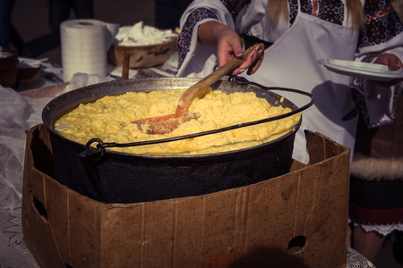 Traditional Romanian food, hominy (mamaliga) prepared in a caldron on fireの写真素材