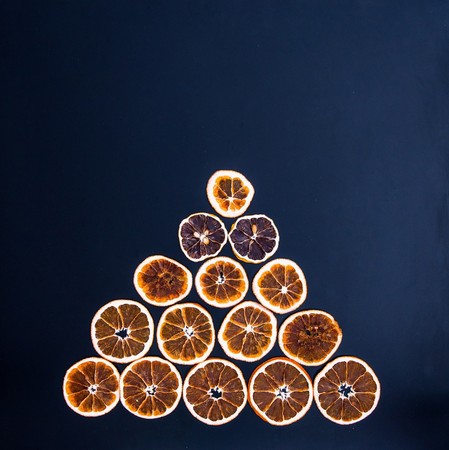 Christmas tree made from dried orange slices on black background