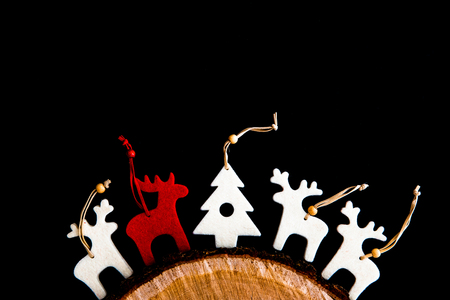 Red and white felt rein deers and fir tree isolated on black. Christmas background with handmade ornamentsの写真素材