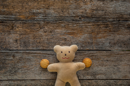 Adorable teddy bear holding cookies on wooden table. Space for textの写真素材
