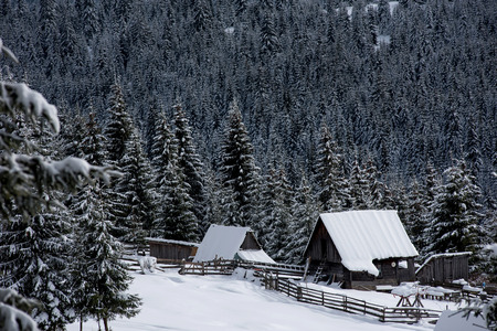 Snow covered mountain wooden hut. Cottage in the mountains at winter