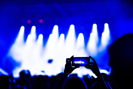 People taking photographs with touch smart phone during a music concertの写真素材
