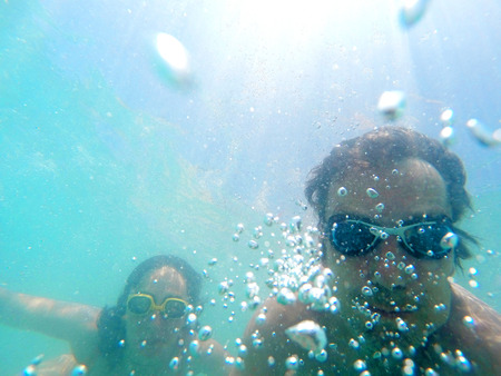 Underwater photo of a young couple diving in the seaの写真素材