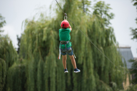 CLUJ, ROMANIA - JUNE 17, 2018: Child descend on a zipline in the park during the Sports Festivalのeditorial素材