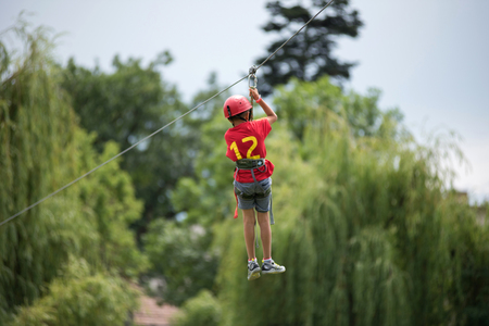 CLUJ, ROMANIA - JUNE 17, 2018: Child descend on a zipline in the park during the Sports Festival