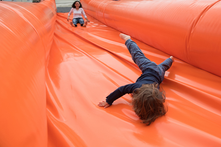Kid and mother slide on a giant inflatable sliderの写真素材