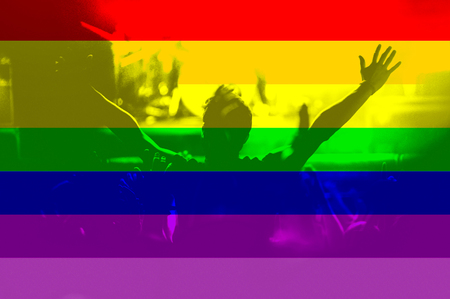 Pride parade, people with raised arms and background of gay rainbow flagの写真素材