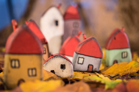 Playground for children, arrangement of painted toy wooden houses on autumn leaves. Childhood conceptの写真素材