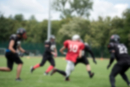 Blurred American football players in action during a matchの写真素材