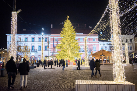 CLUJ NAPOCA, ROMANIA - DECEMBER 30, 2017: Cheerful people enjoying the Christmas market at night in the center of the old city and buying presents and goodiesのeditorial素材