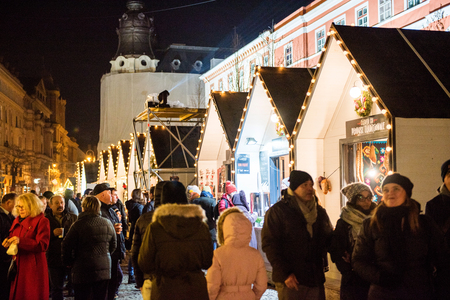 CLUJ NAPOCA, ROMANIA - DECEMBER 30, 2017: Cheerful people enjoying the Christmas market at night in the center of the old city and buying presents and goodiesのeditorial素材