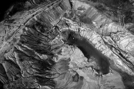 Black and white image of abandoned industrial exploitation, opencast mine. Aerial drone view