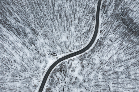 Top view of winter forest road. Aerial drone imageの写真素材