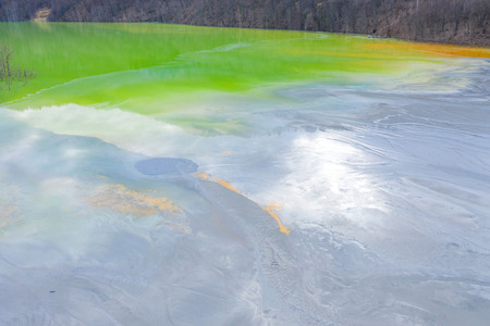 Aerial drone view of toxic chemical residuals flooding a lake from a copper and gold mine...
