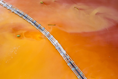 Aerial view of mining settling basin and lime supply. Colorful red polluted mine water from copper...