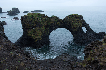 Gatklettur arch basalt rocks formation at the coast of Atlantic Ocean in Arnarstapi in Icelandの写真素材