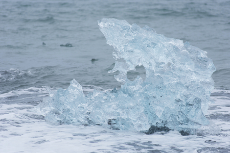 Diamond beach in Iceland on the Atlantic ocean coast. Icebergs which fill Jokulsarlon glacier lagoon...