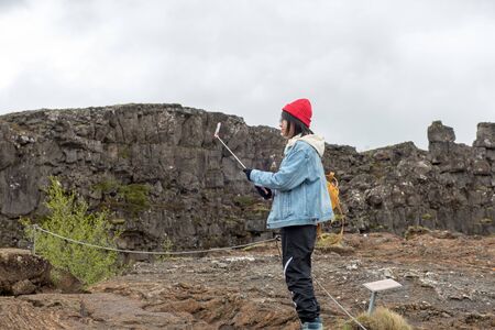 THINGVELLIR, ICELAND - MAY 20, 2019: Asian tourists making a selfie at Thingvellir National Park a site of historical, cultural, and geological significanceのeditorial素材