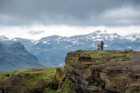 DYRHOLAEY, ICELAND - MAY 21, 2019: Tourists trekking on the rocky coastline of Dyrholaey, Vikのeditorial素材