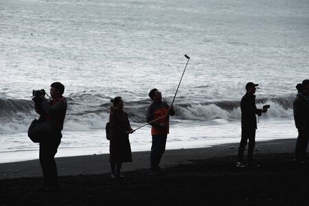 VIK, ICELAND - MAY 21, 2019: Tourists visiting the Reynisfjara beach and taking selfies on the Atlantic coast of Southern Iceland in Vikのeditorial素材