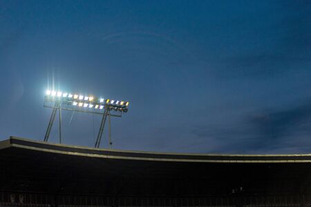 Stadium lights against blue sky during sunset