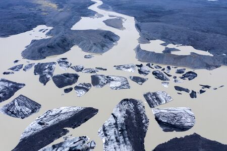 Aerial drone view of floating icebergs as a result of climate change in Svinafelsjokull glacier lake...