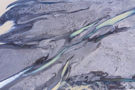 Aerial drone view of glacial river system transporting water from the melting glaciers of...