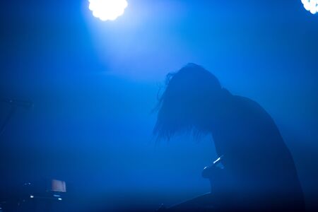 Silhouette of a guitarist in blue stage lightsの写真素材
