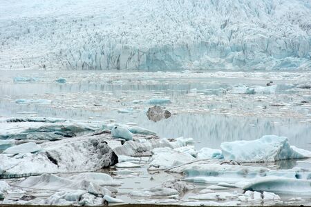 Floating icebergs drifting in the water in Fjallsarlon glacier lagoon, Vatnajokull National Park,...