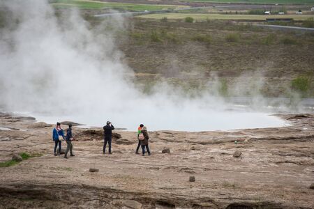 STROKKUR GEYSER, ICELAND - MAY 20, 2019: Tourists visiting and waiting for the eruption of Strokkur...