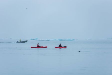 JOKULSARLON, ICELAND - MAY 22, 2019: Man paddling in a kayak in the freezing waters of Jokulsarlon glacier lagoon between icebergsのeditorial素材