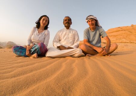 WADI RUM, JORDAN - MAY 19, 2018: Tourists posing with their bedouin guide in the Wadi Rum desert. Many of bedouins are working now as guides instead of shepherdsのeditorial素材