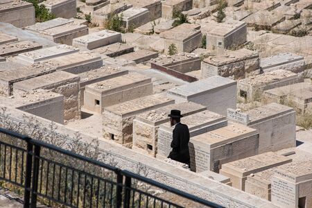 JERUSALEM, ISRAEL - MAY 16, 2018: Orthodox Jew  visiting the graveyards in the Jewish Cemetery on the Mount of Olives where according to midrash the Resurrection of the Dead would beginのeditorial素材