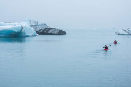 JOKULSARLON, ICELAND - MAY 22, 2019: Man paddling in a kayak in the freezing waters of Jokulsarlon glacier lagoon between icebergsのeditorial素材