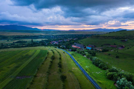 Aerial view of a storm and clouds above a village roadの写真素材