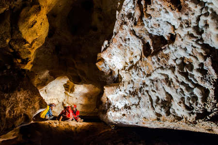Group of speleologists resting during a cave exploration. Caving is a dangerous extreme sport practiced by professionalsの写真素材