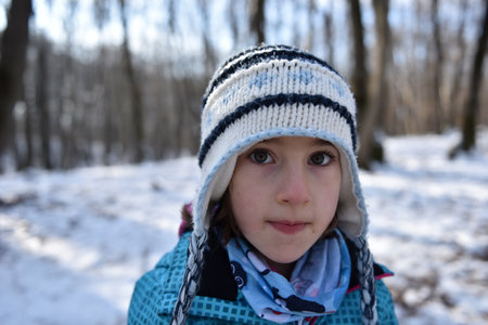 Portrait of a beautiful baby girl in the forest at winter