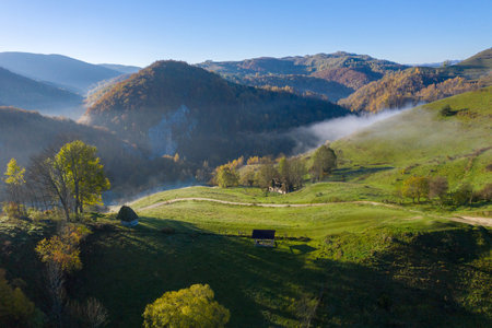 Mountain countryside homestead in the autumn. Wooden barns, aerial drone view. Transylvania, Romaniaの写真素材