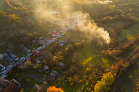 Aerial view of village in the autumn, burning grass and smoke. Valeni, Transylvania, Romaniaの写真素材