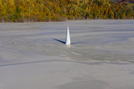 Aerial view of a church tower with cross, buried under mud and mining residuals. Apocalyptic scene in Transylvania, Romaniaの写真素材
