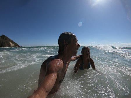 Sea waves splashing on happy couple. Just married conceptの写真素材