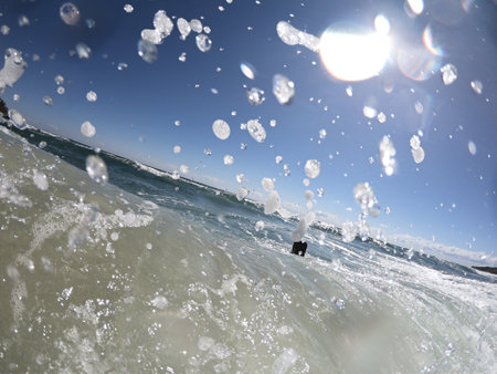 Powerful sea waves splashing on a cheerful woman bodyの写真素材