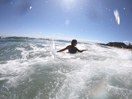 Powerful sea waves splashing on a cheerful woman bodyの写真素材
